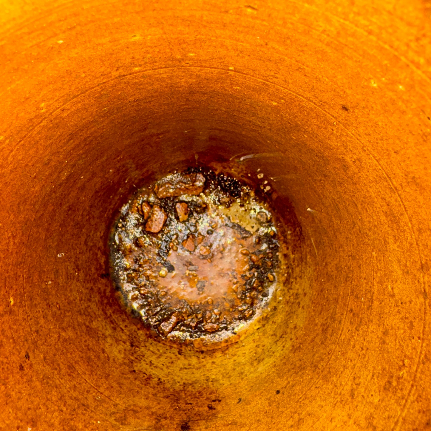 Close-up of a rusty metal surface with a central circular area showing signs of corrosion.