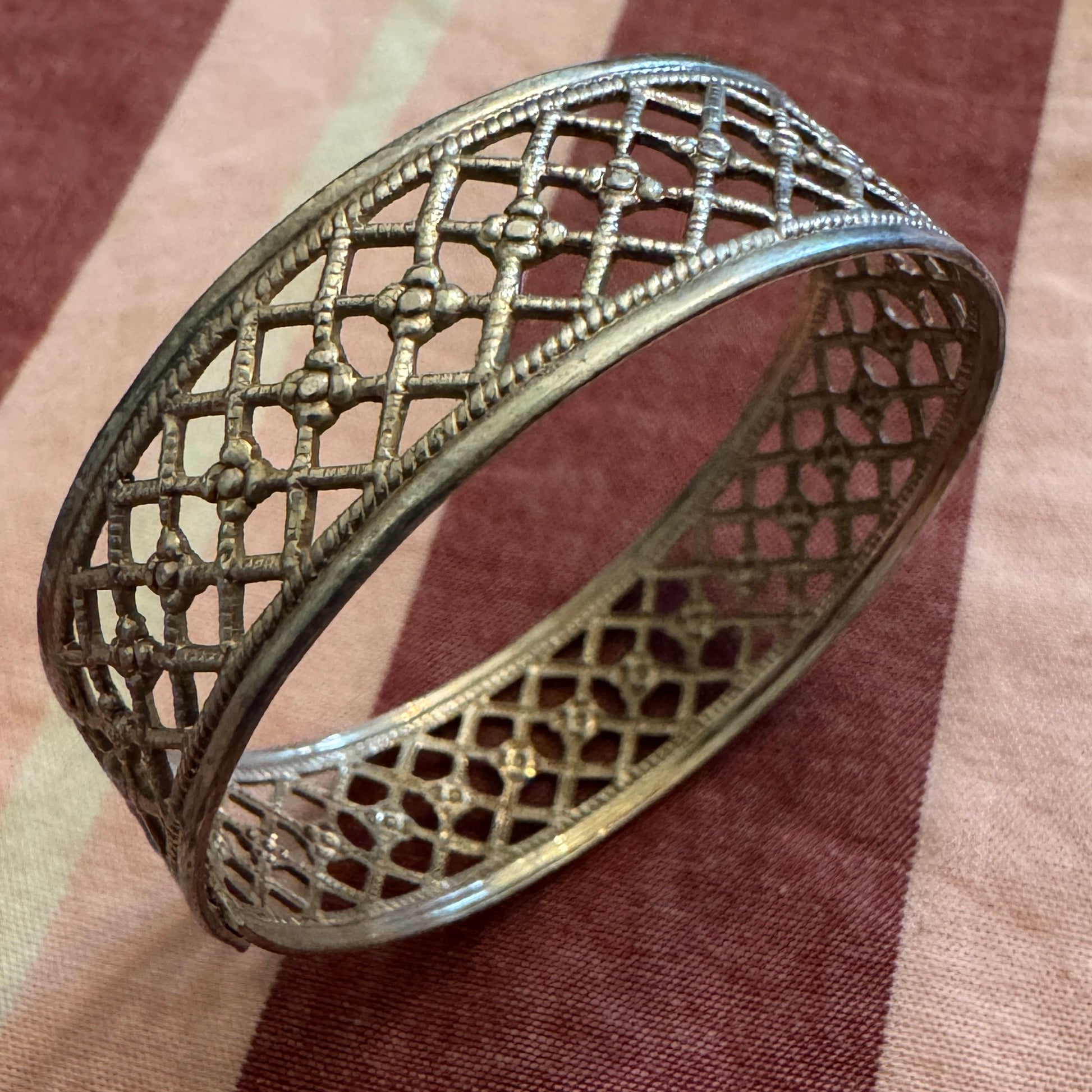 Decorative silver napkin ring on a brown fabric background