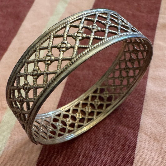 Decorative silver napkin ring on a brown fabric background