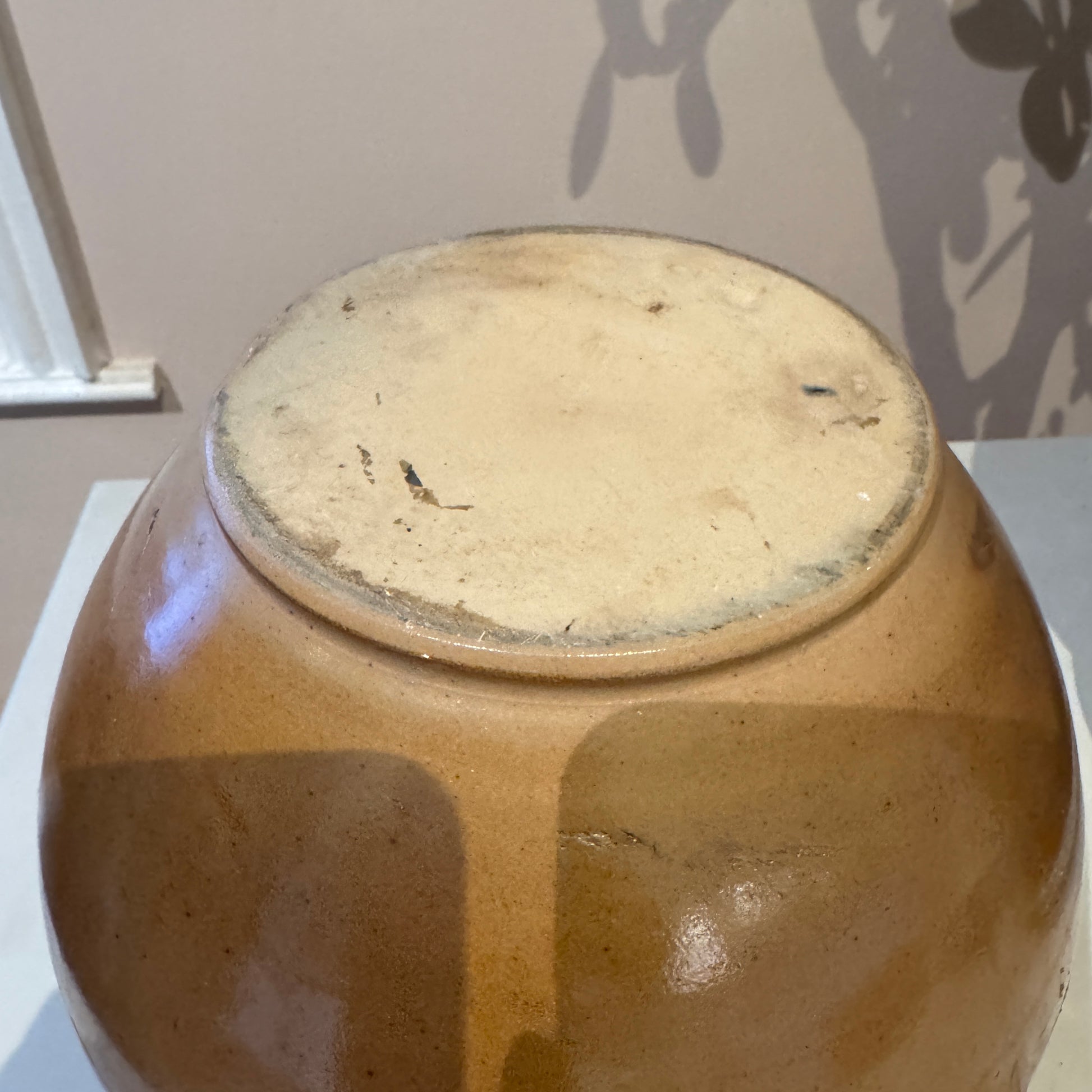 Brown ceramic jar with a textured surface on a white background