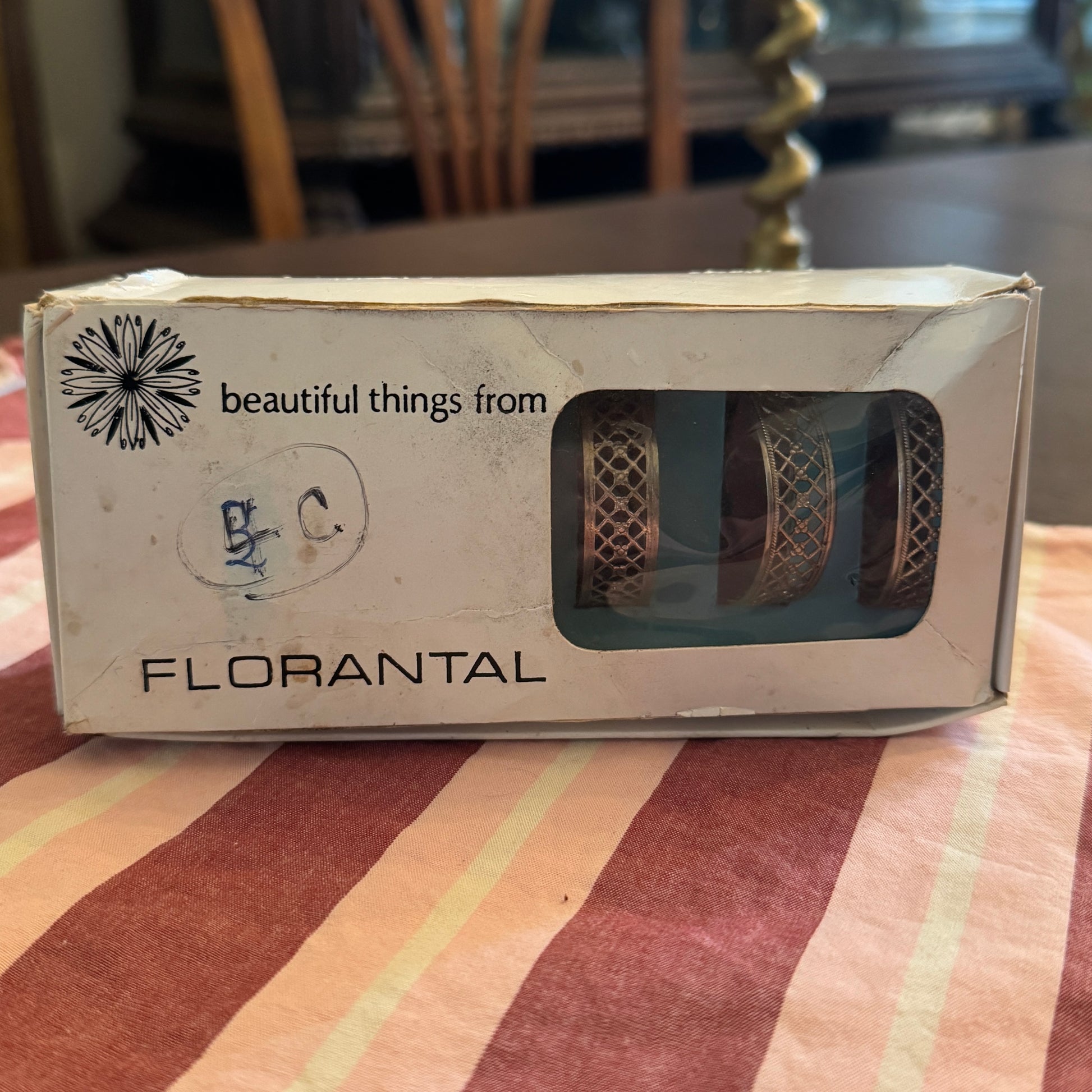 Florantal silver plated napkin rings vintage 60s product packaging on a striped tablecloth